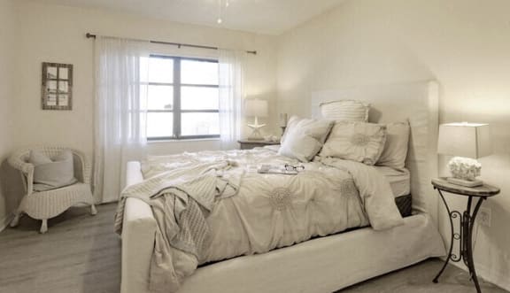 a white bedroom with a bed and a window