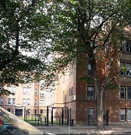 A brown building with a black fence in front of it.