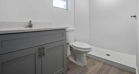 A white toilet sits in a bathroom with a sink and a window.