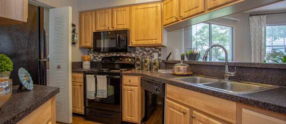 a large kitchen with wooden cabinets and a sink
