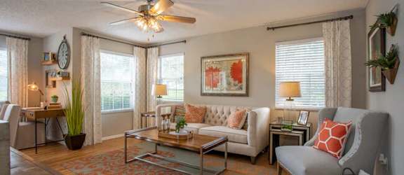 a living room filled with furniture and a ceiling fan