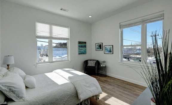 a bedroom with a bed and two windows