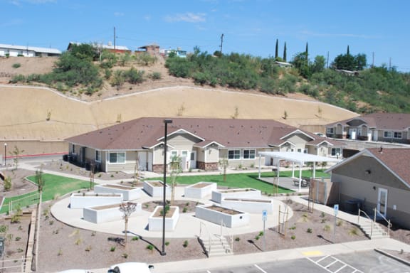 a group of houses on a hillside with a grassy area in front of them
