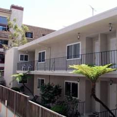 A balcony with a black railing and a tree in front of a building.