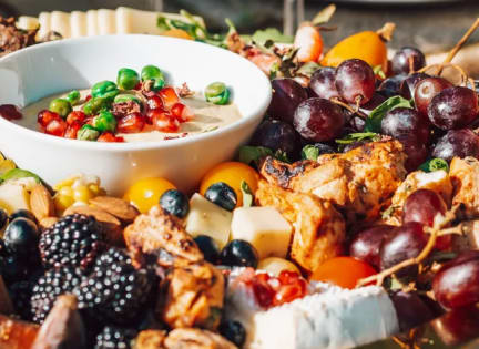 a plate of food on a table with a bowl of cheese and fruit at Village of Chandler, Chandler