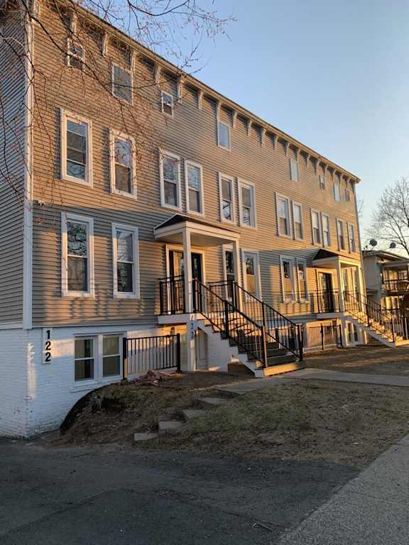 a row of houses with stairs and a sidewalk
