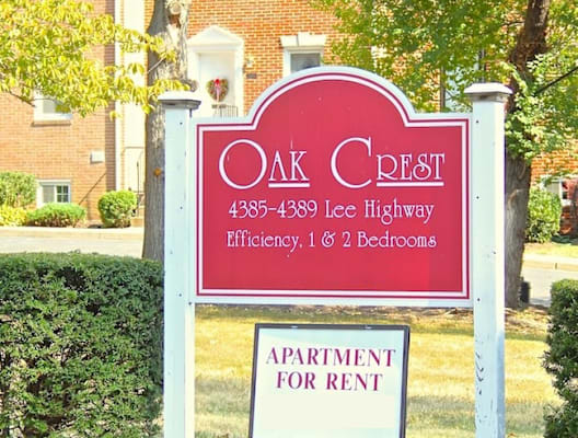 a sign in front of a building that reads oak crest apartments