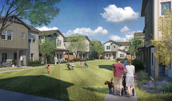 A family is walking their dog in a park-like setting with houses in the background.