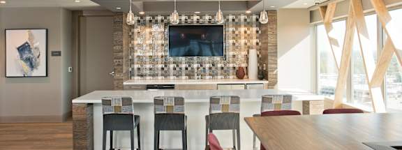 a kitchen and dining area with a bar and a television