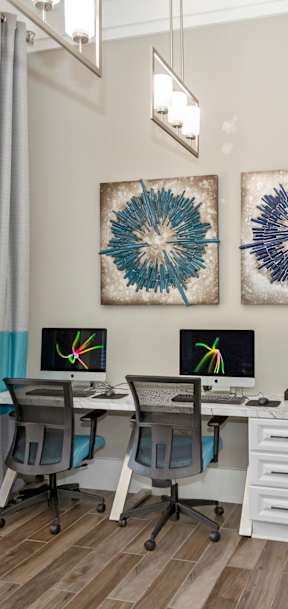 a home office with two windows and two desks with computers