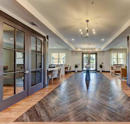 A long hallway with a wooden floor and glass doors on both sides.
