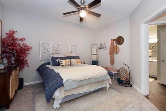 a bedroom with a bed and a ceiling fan