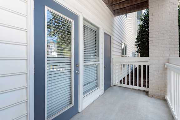 a patio with a door and a porch with a railing