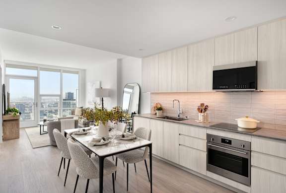 A modern kitchen with a dining table set for four. at Olympic + Hill Apartments, Apartments, Los Angeles, CA