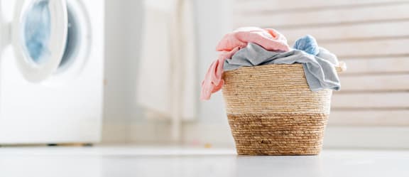 a basket filled with laundry sitting next to a washing machine