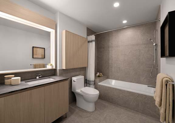 A modern bathroom with a toilet, sink, and bathtub. at Olympic + Hill Apartments, Apartments, Los Angeles, CA