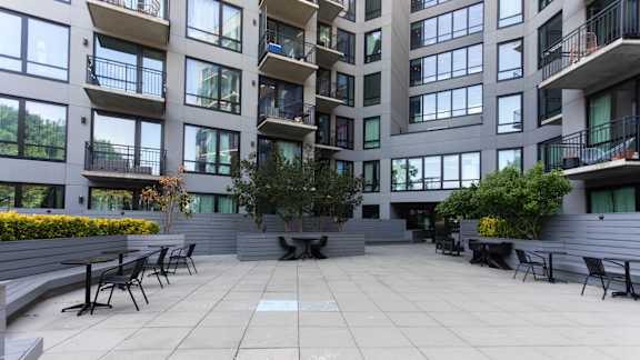 Courtyard seating area with tiered planters at 1134 Fulton Street Apartments, New York
