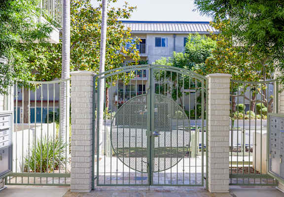 a gate with a house behind it behind a fence