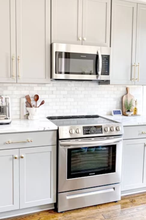 A kitchen with a stove and a microwave above it.