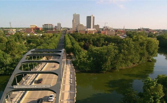 a bridge over a river with a city in the background at The Pearl, Fort Wayne, 46802