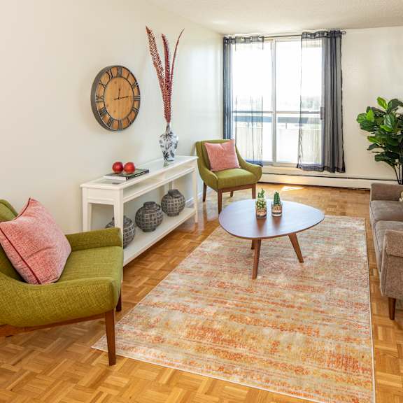 A living room with a grey couch, a round table, and a television.