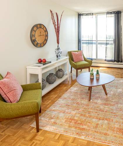 A living room with a green chair and a brown table.
