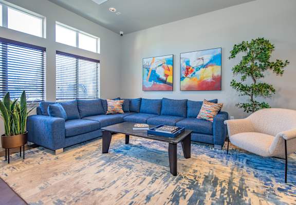 A living room with a blue couch and a white chair.