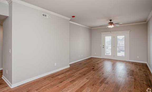 A room with wooden floors and a ceiling fan.