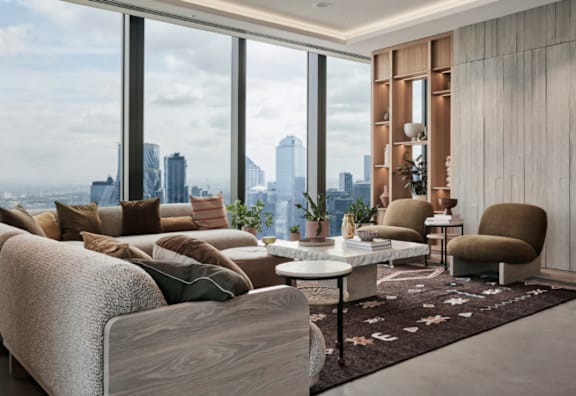A modern living room with a view of the city skyline at dusk.