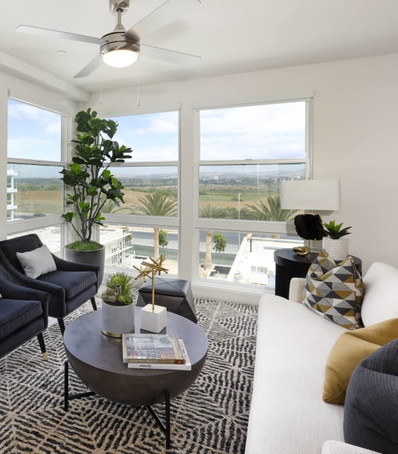 an open living room with a large window and a view of the city