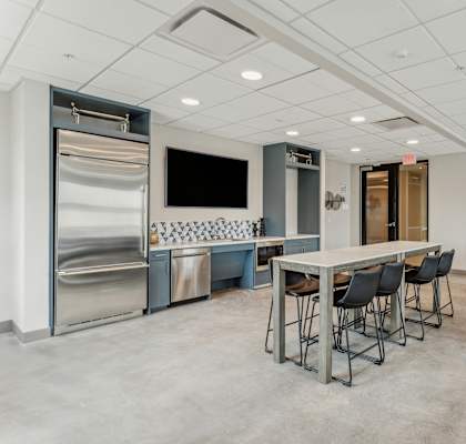 a dining room with a table and chairs and a kitchen and television