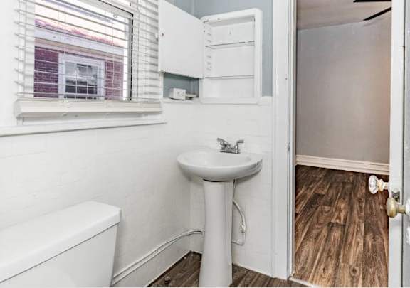 A white sink and toilet in a small bathroom.