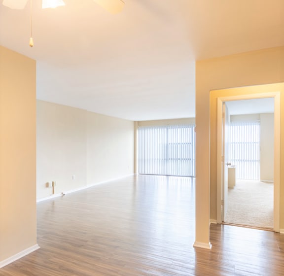 an empty living room with wood floors and white walls
