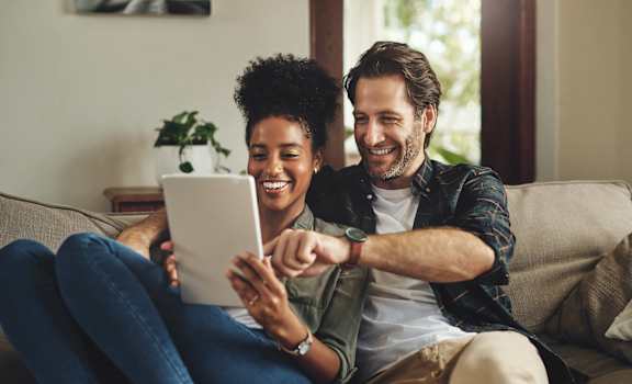 a man and woman sitting on a couch looking at a tablet computer at Pleasant View Estates, Griswold, Connecticut