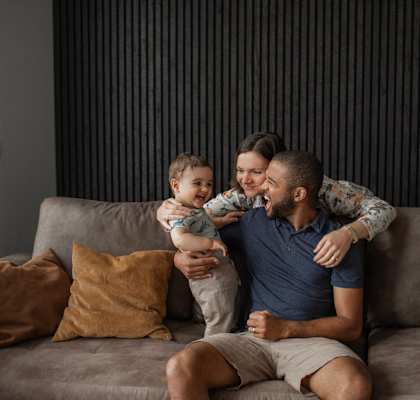 a man sitting on a couch with a baby and a woman holding a child at The Walker Virginia Center in Glen Allen, Virginia