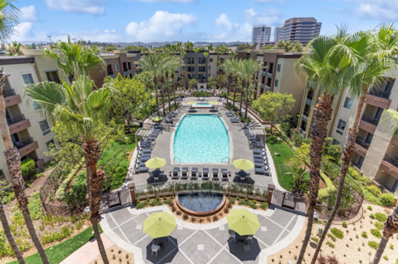 A swimming pool in front of a multi-story apartment building.
