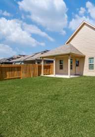a backyard with a house and a fence