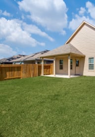 a backyard with a house and a fence