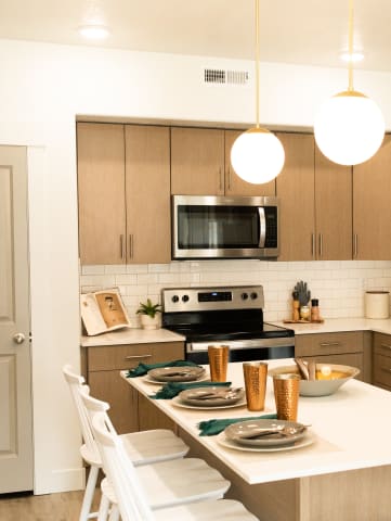 a kitchen with wooden cabinets and a white table with white chairs