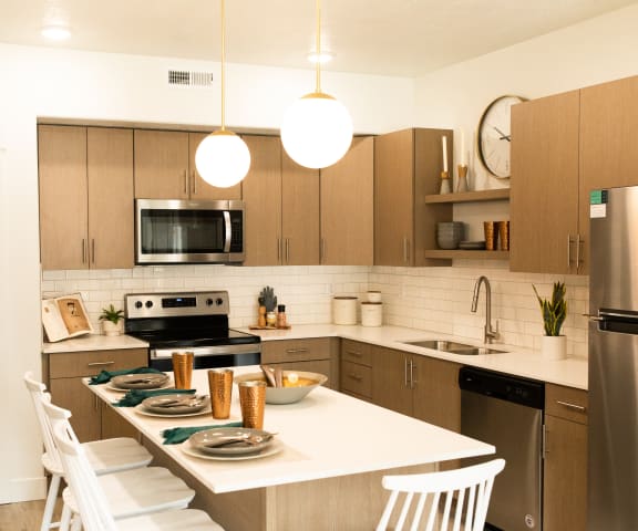 a kitchen with wooden cabinets and a white table with white chairs