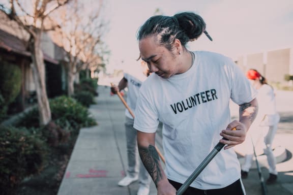 volunteer sweeping floors  at The Verandas, Canoga Park, California