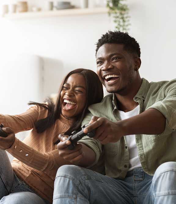 Two people playing video games on a couch.