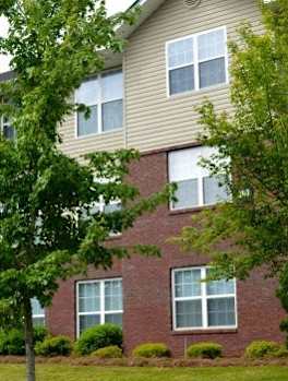 an apartment building with a tree in front of it