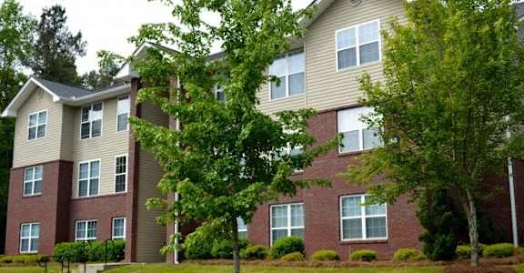 an apartment building with a tree in front of it