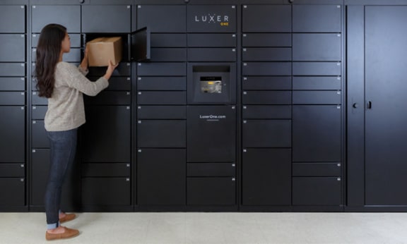 a woman is loading a box into some lockers