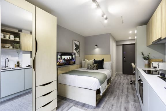a bedroom with a bed and a desk in a room