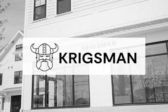 A black and white image of a building with a sign that reads "KRIGSMAN".