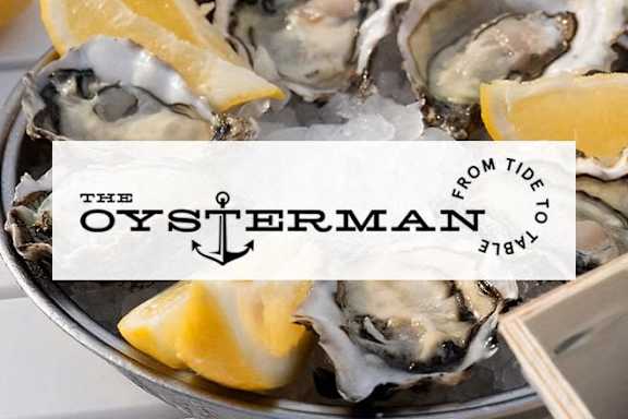 A bowl of oysters with a sign that says The Oysterman.