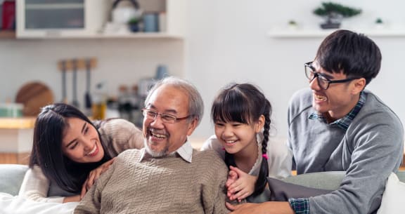 a family sitting on a couch with their granddaughter and grandparents