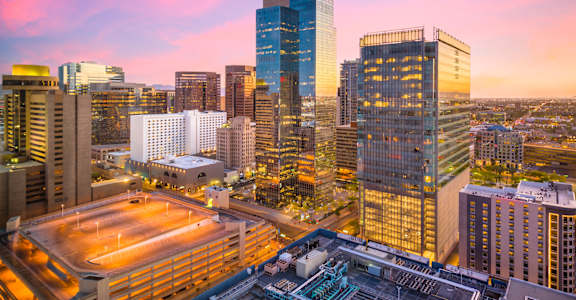 A cityscape with a stadium in the foreground and buildings of varying heights.